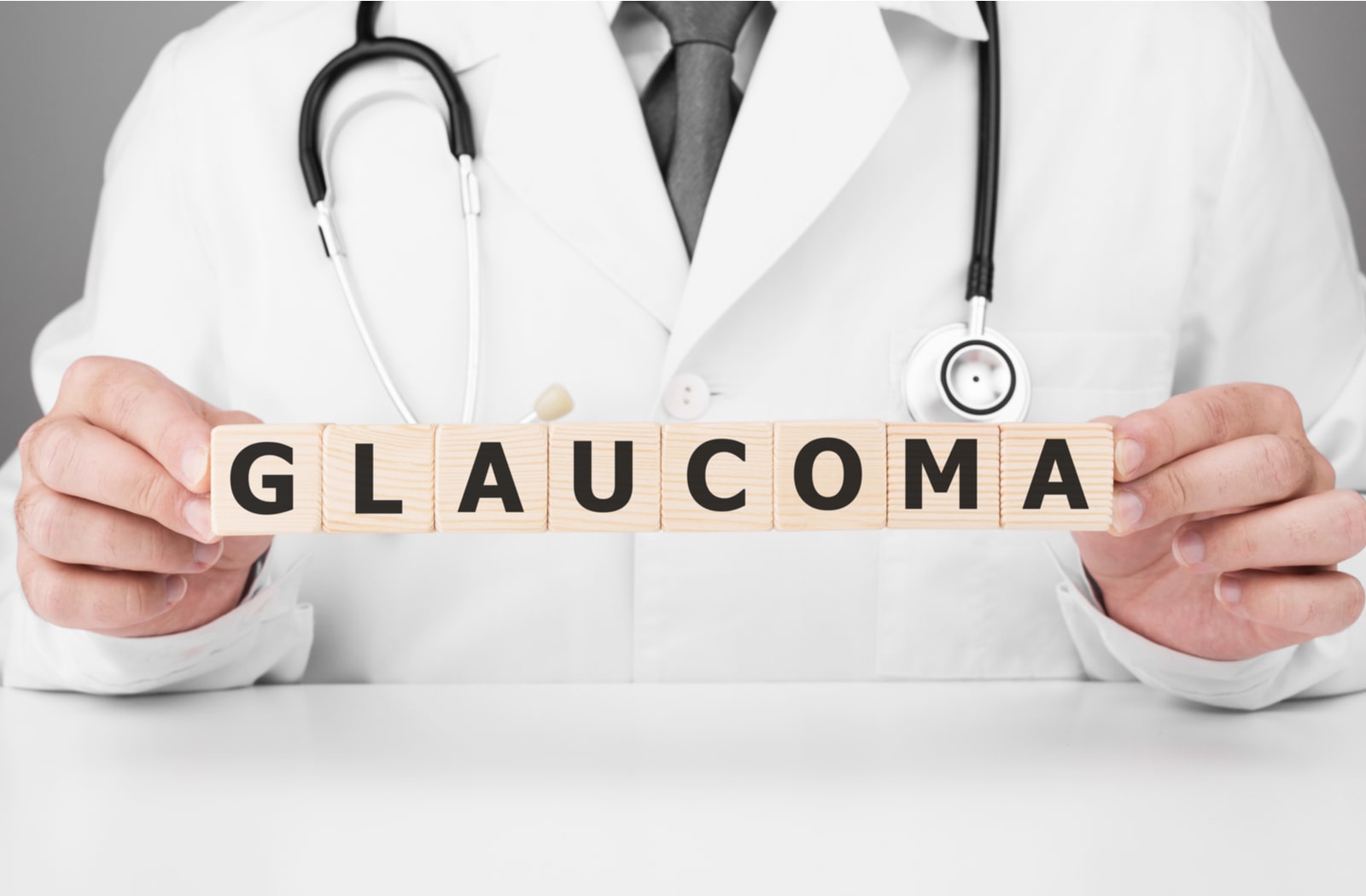 A doctor holding wooden blocks that spell out "glaucoma"