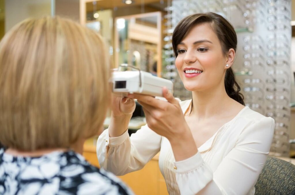 An optician uses a pupilometer to measure their patient's pupillary distance.