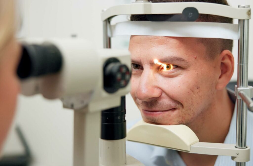 A person undergoing an eye exam with a slit lamp, as a focused light is directed into their eye.