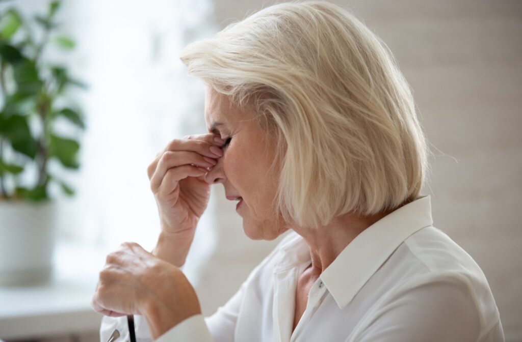 Rubbing the bridge of the nose due to vision strain and fatigue.
